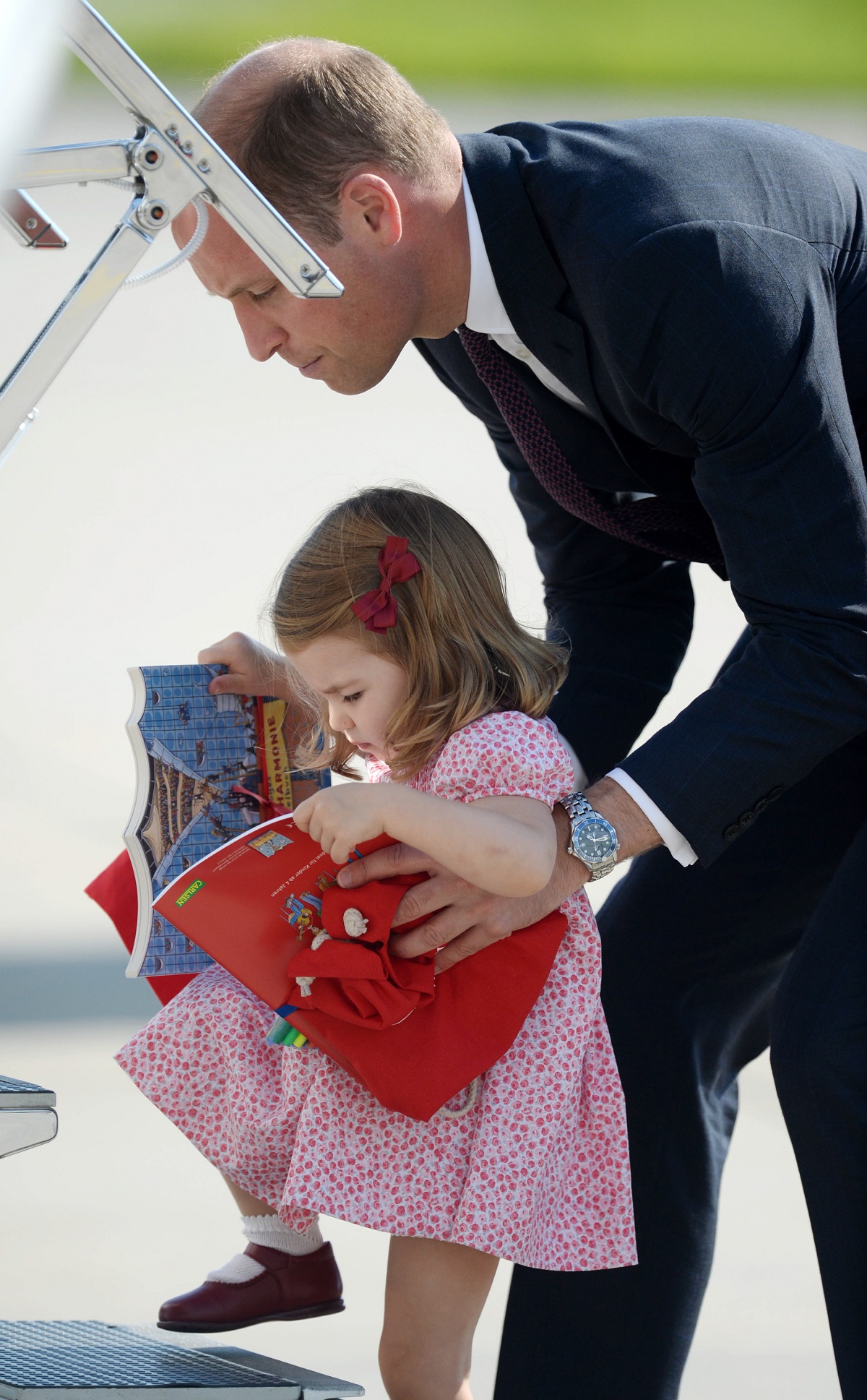 Prince William helping Princess Charlotte onto an aircraft at Hamburg airport on the last day of their official visit to Poland and Germany