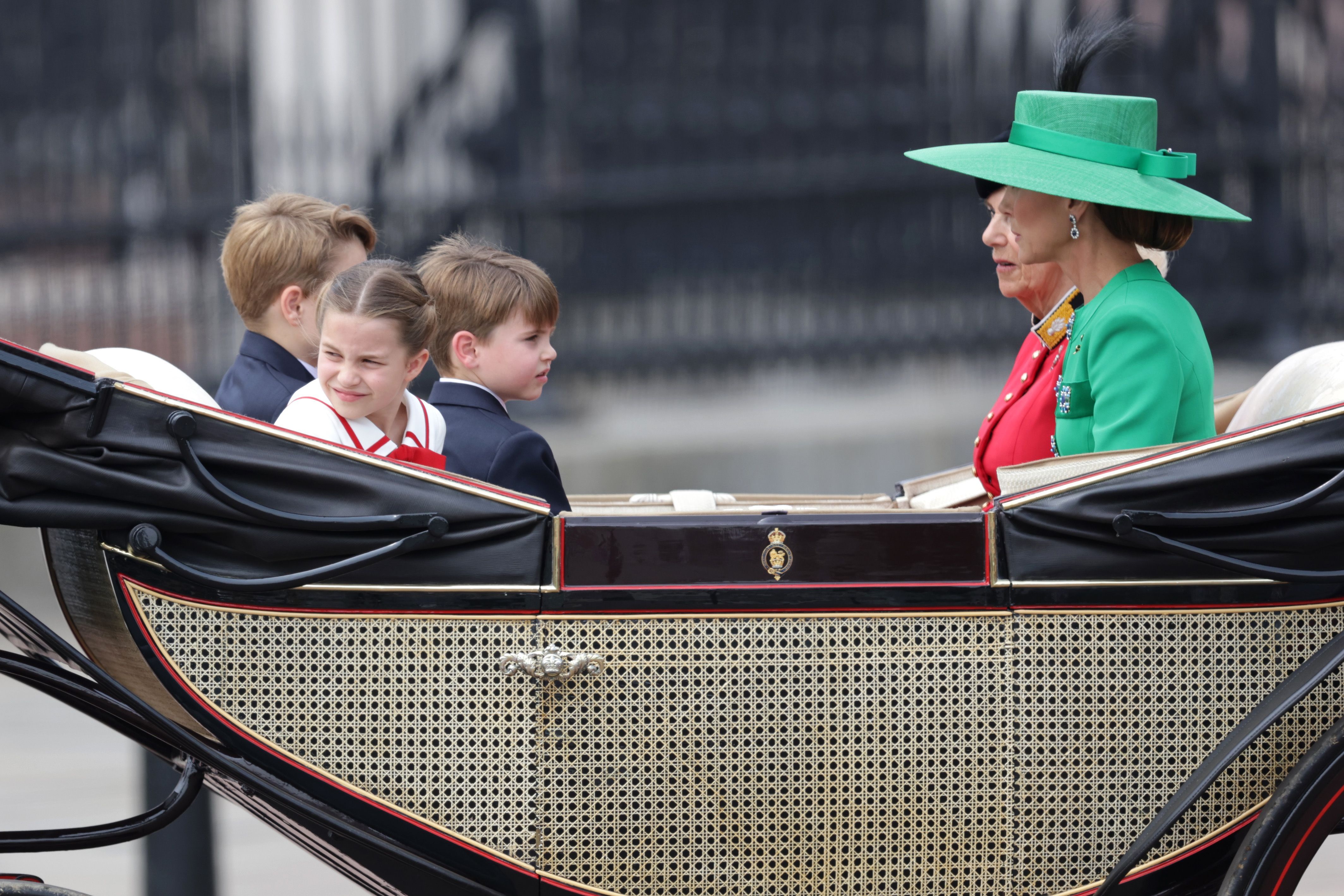 La princesa Charlotte mirando hacia atrás mientras viaja en un carruaje con sus hermanos, su madre (Kate Middleton) y su abuelastra (Camilla Parker Bowles)