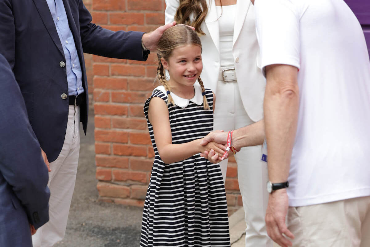 Princess Charlotte, who seemingly wiped her hand on her dress after a 2022 Commonwealth Games introduction, according to a body language expert, shakes hands
