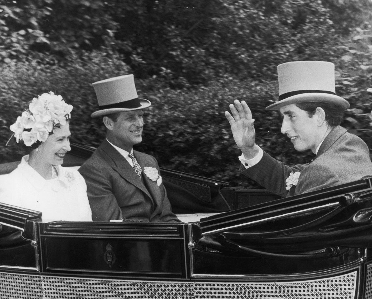 Queen Elizabeth II, Prince Philip, and then-Prince Charles riding in a carriage on their way to the Ascot race meeting in 1968