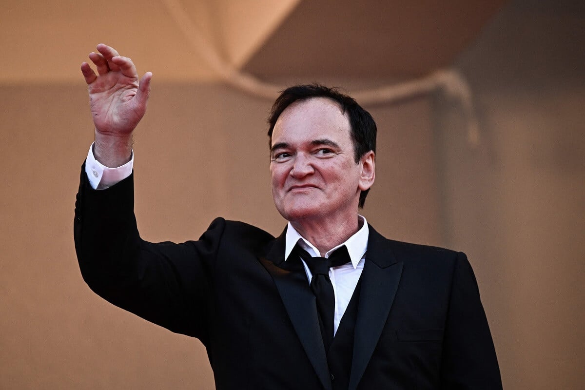 A picture of Quentin Tarantino waving in a suit while attending a screening for the film 'Elemental'.