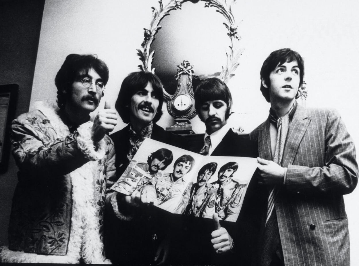 Beatles members (from left) John Lennon, George Harrison, Ringo Starr, and Paul McCartney standing and holding a 'Sgt. Pepper's Lonely Hearts Club Band' record sleeve.