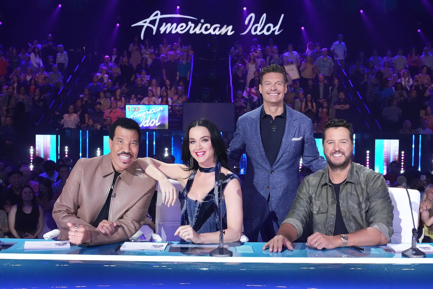 'American Idol' host Ryan Seacrest standing next to Lionel Richie, Katy Perry, and Luke Bryan
