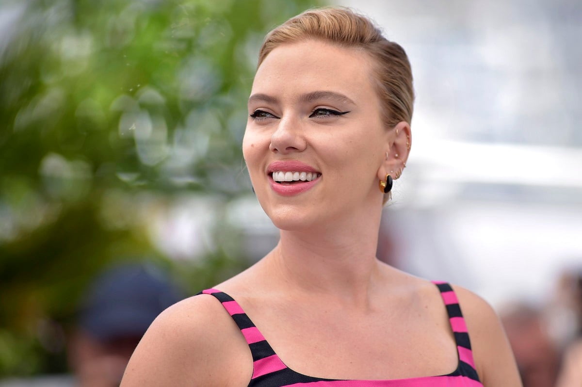 Scarlett Johansson smiling while her photo is being taken at the Cannes Film Festival.