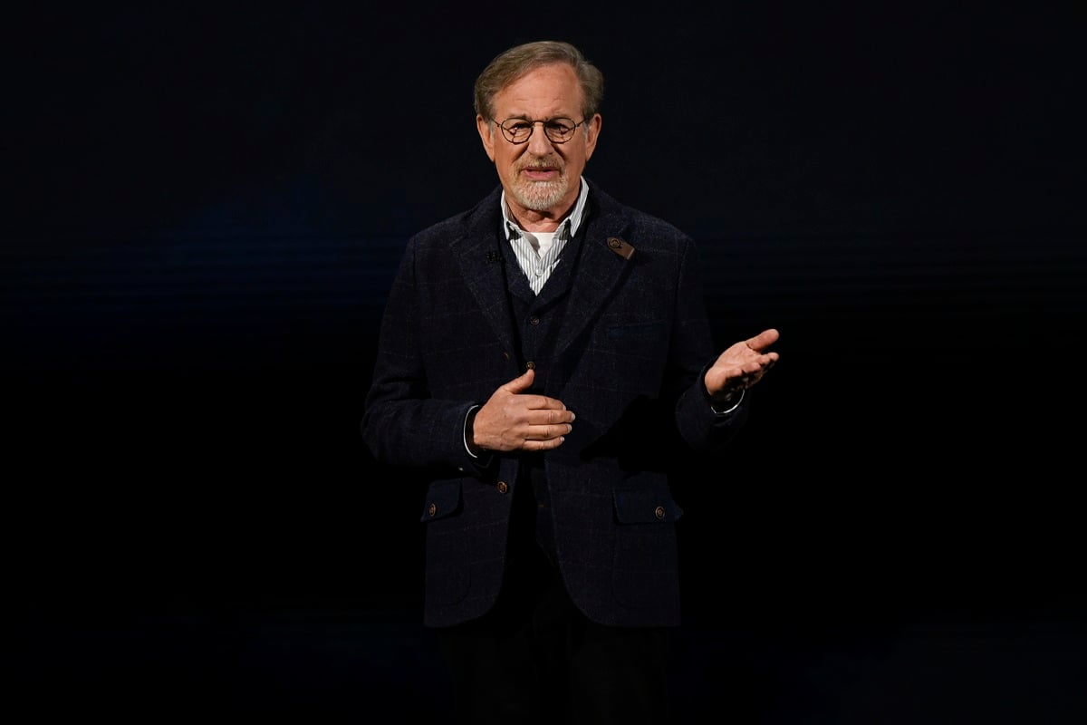 A picture of Steven Spielberg in a black suit speaking during an Apple product launch event.