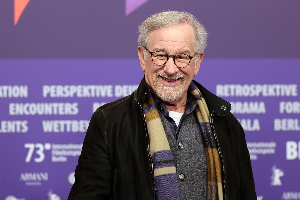 Steven Spielberg smiling while taking a picture at a press conference for 'The Fablemans'.