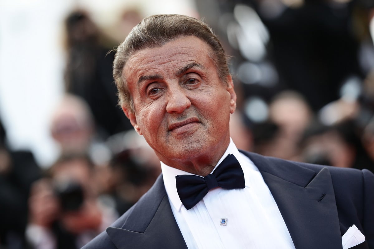 Sylvester Stallone attending a movie screening while wearing a suit.