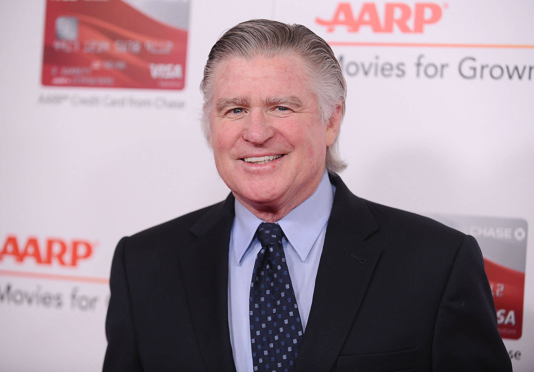 Treat Williams wearing a suit and tie at an AARP event