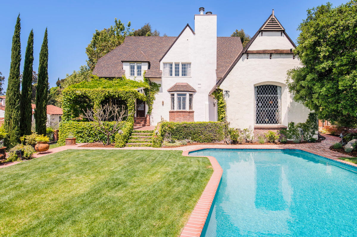 Exterior of Walt Disney's storybook-style home with pool in foreground