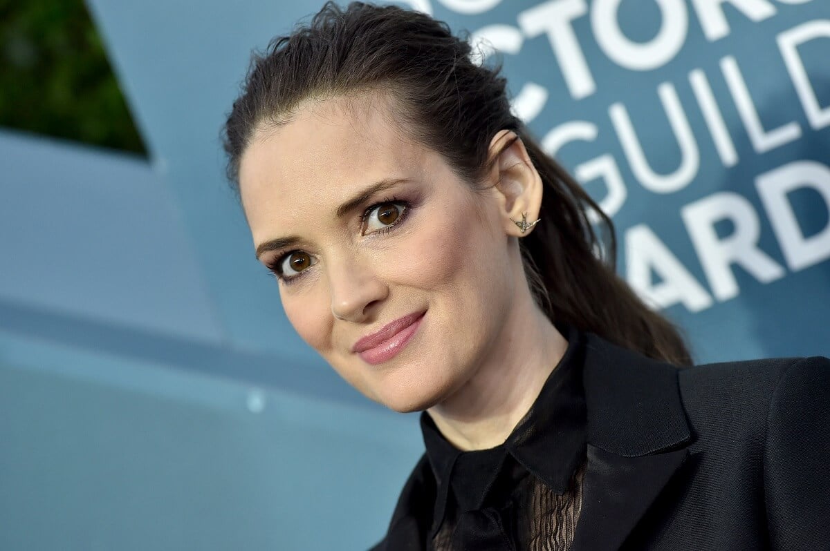 Winona Ryder taking a picture in a suit at the 26th Annual Screen Actors Guild Awards.