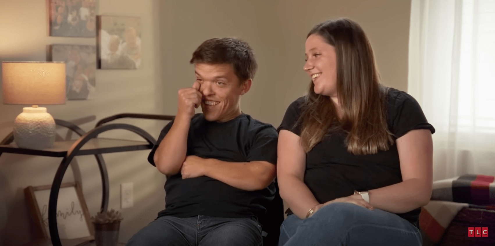 Zach and Tori Roloff from 'Little People, Big World' sitting on a couch laughing