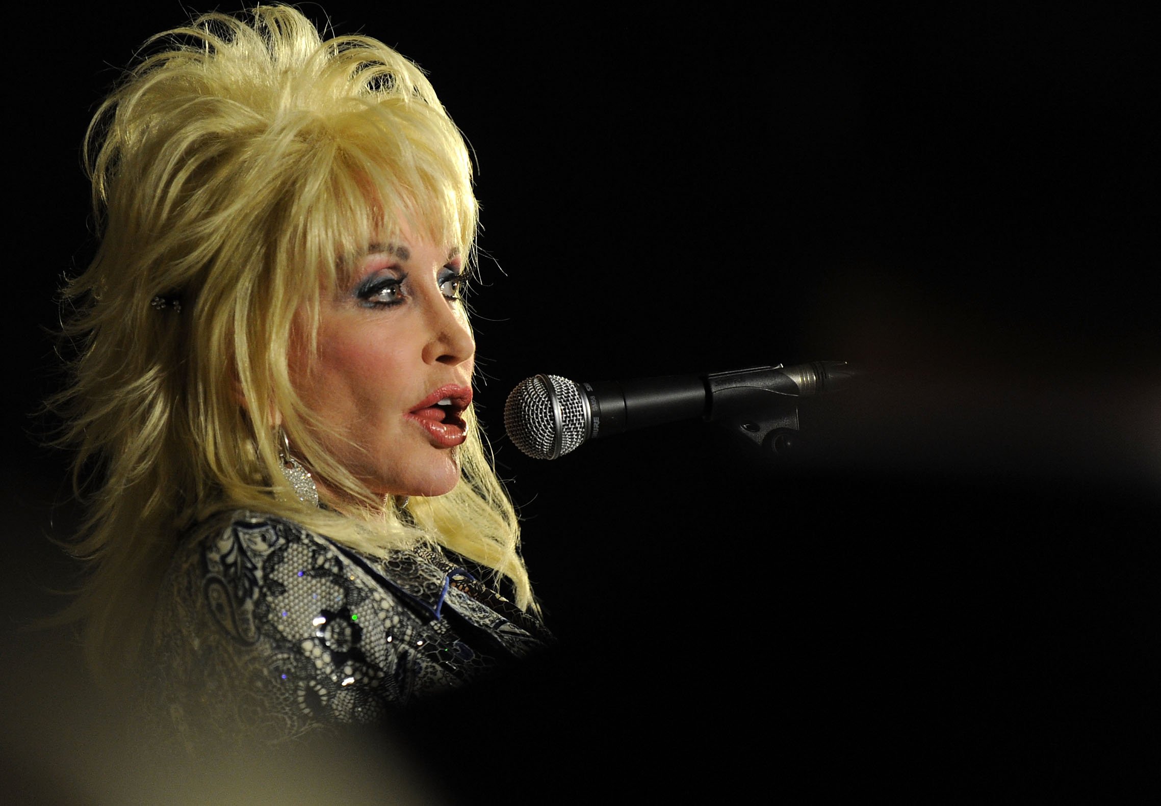 Dolly Parton speaks into a microphone.