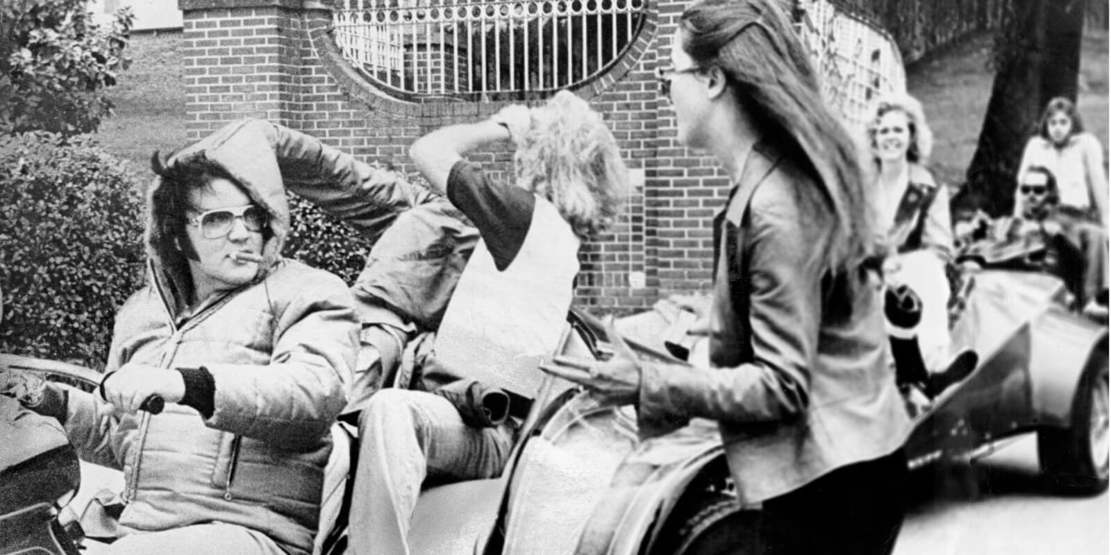 Elvis Presley rides three wheelers with his friends outside of Graceland's gates.