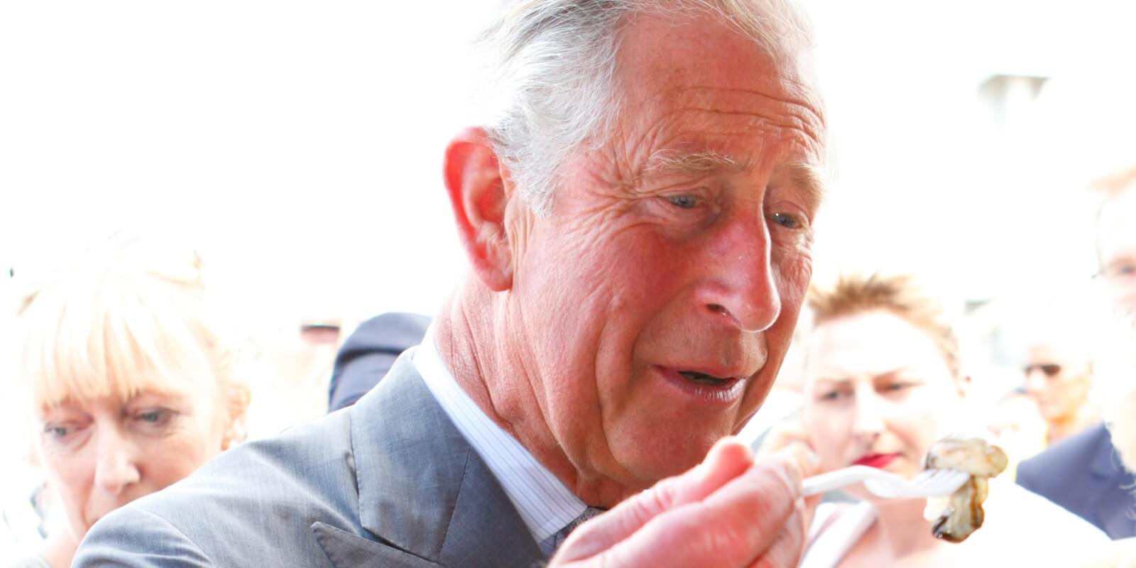 King Charles eats an oyster on July 29, 2013 in Whitstable, England.