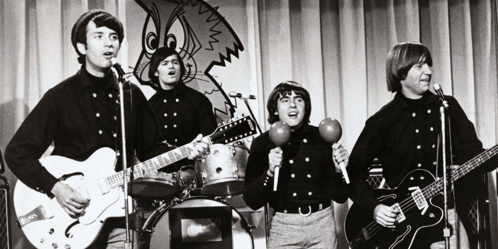 The Monkees members photographed on the set of their television show included Mike Nesmith, Micky Dolenz, Davy Jones, and Peter Tork.