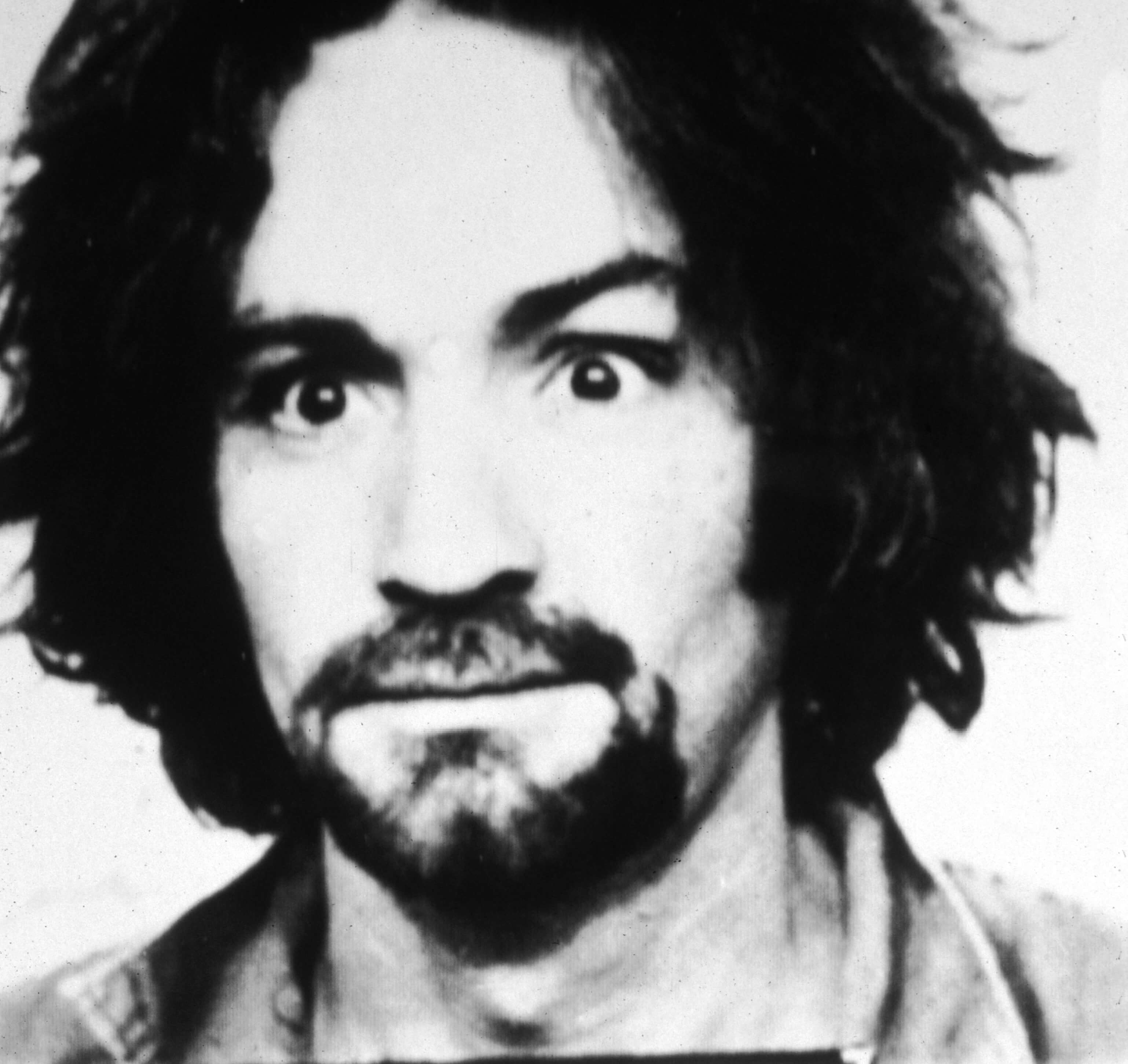 A black-and-white mug shot of Charles Manson
