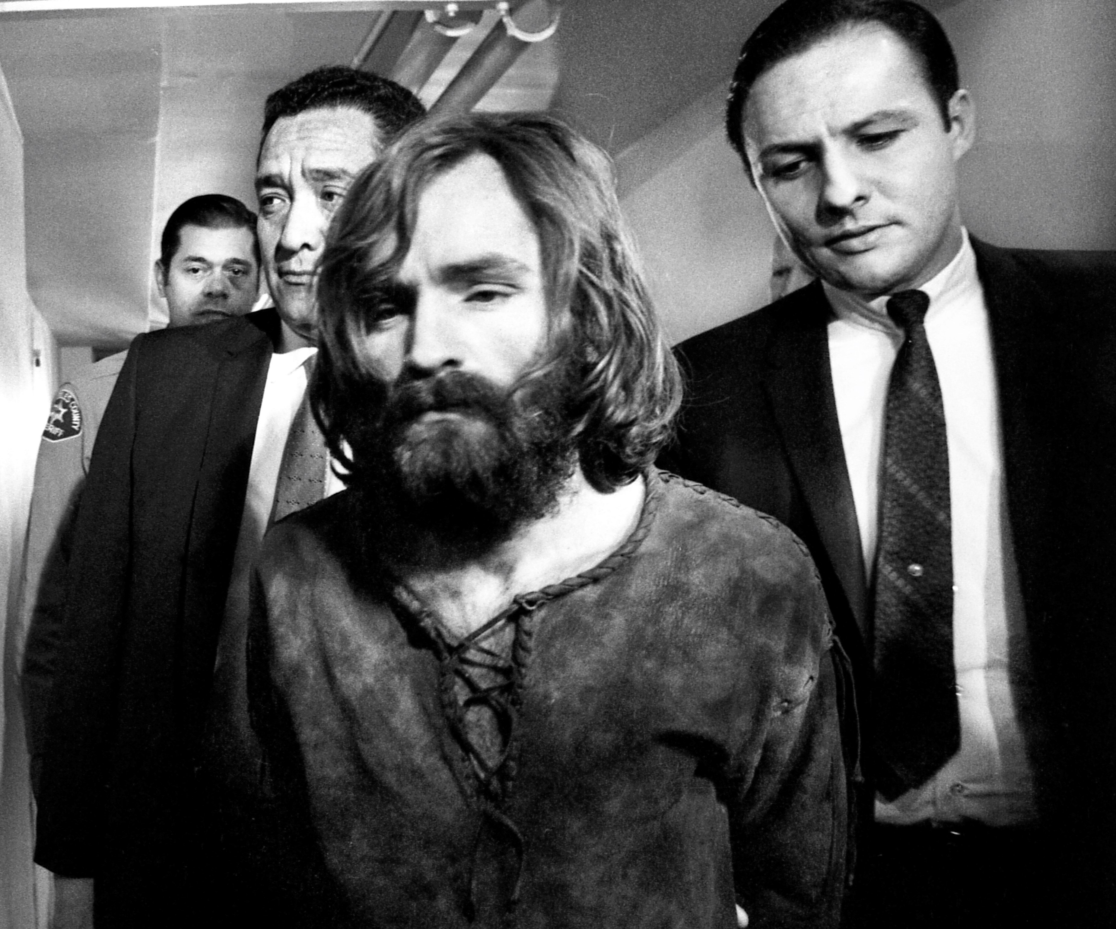 Charles Manson next to two men