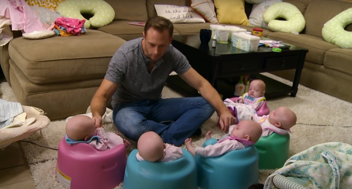 Adam Busby with his infant quints in an episode of 'OutDaughtered'