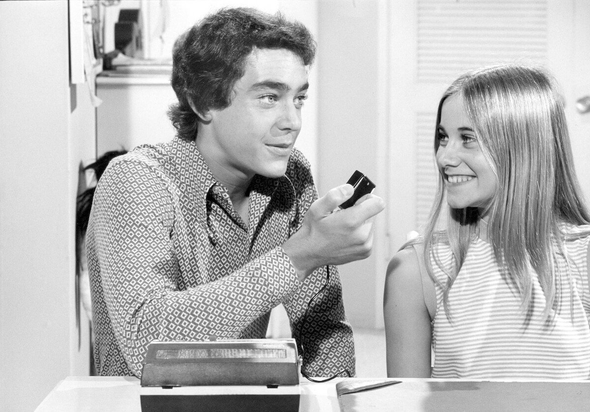 Black and white photo of Maureen McCormick smiling at Barry Williams in an episode of 'The Brady Bunch'