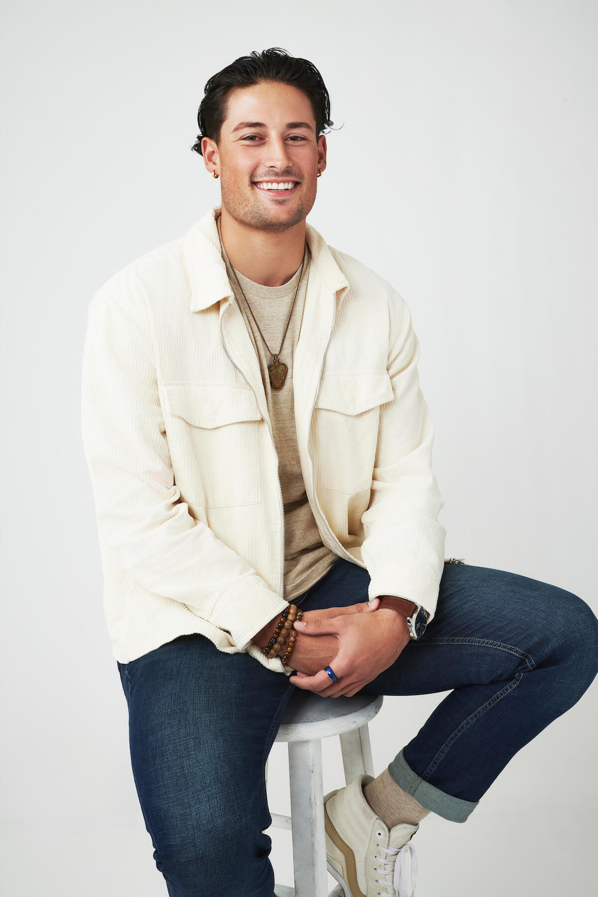 Brayden Bowers from 'The Bachelorette' 2023 sitting on a stool and smiling