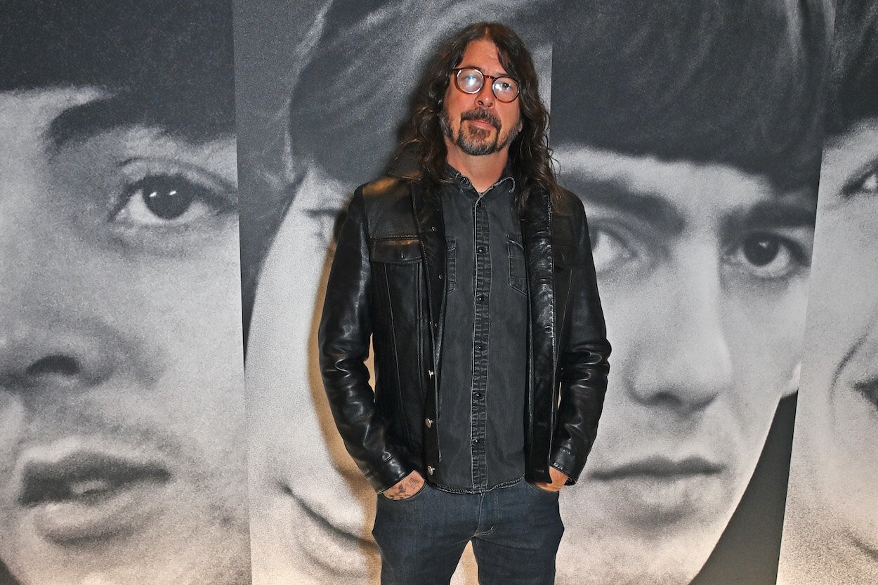 Dave Grohl stands in front of images of The Beatles at the 'Paul McCartney Photographs 1963-64: Eyes of the Storm' photo exhibit.