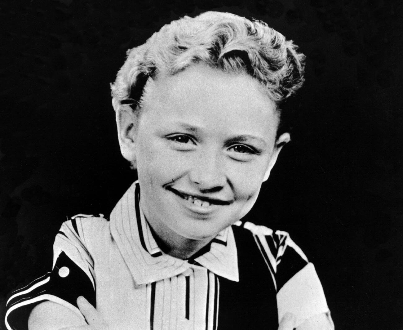 A black and white picture of a young Dolly Parton wearing a collared shirt.