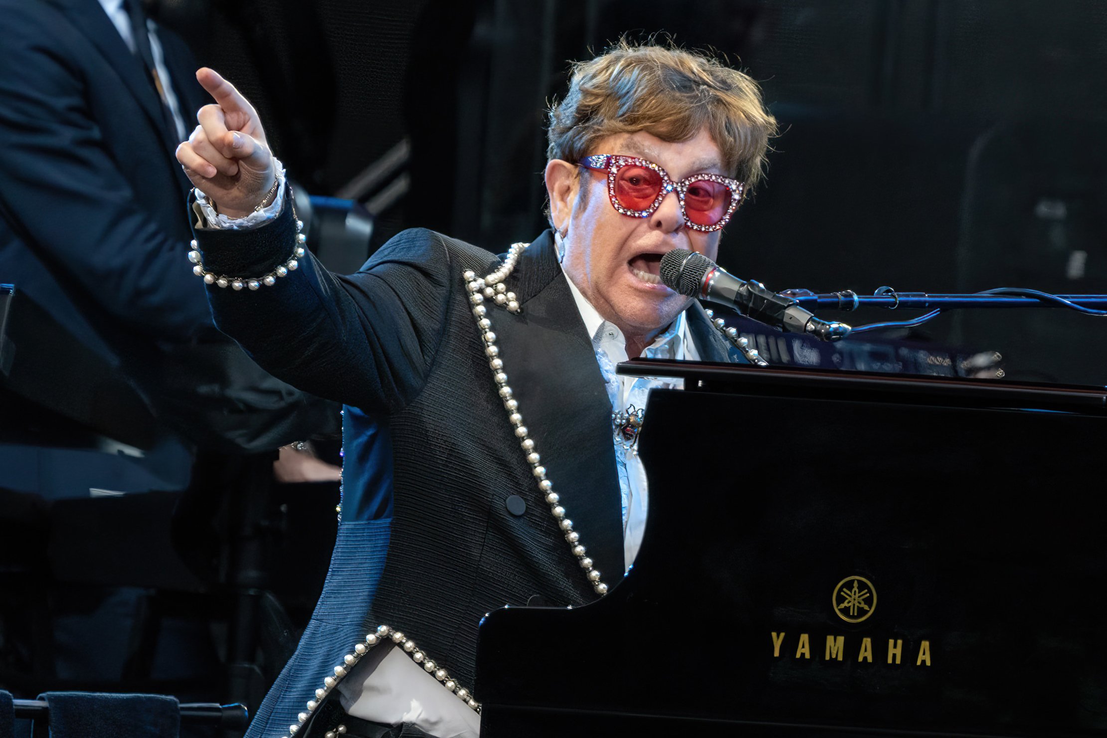 Elton John pointing at the piano.