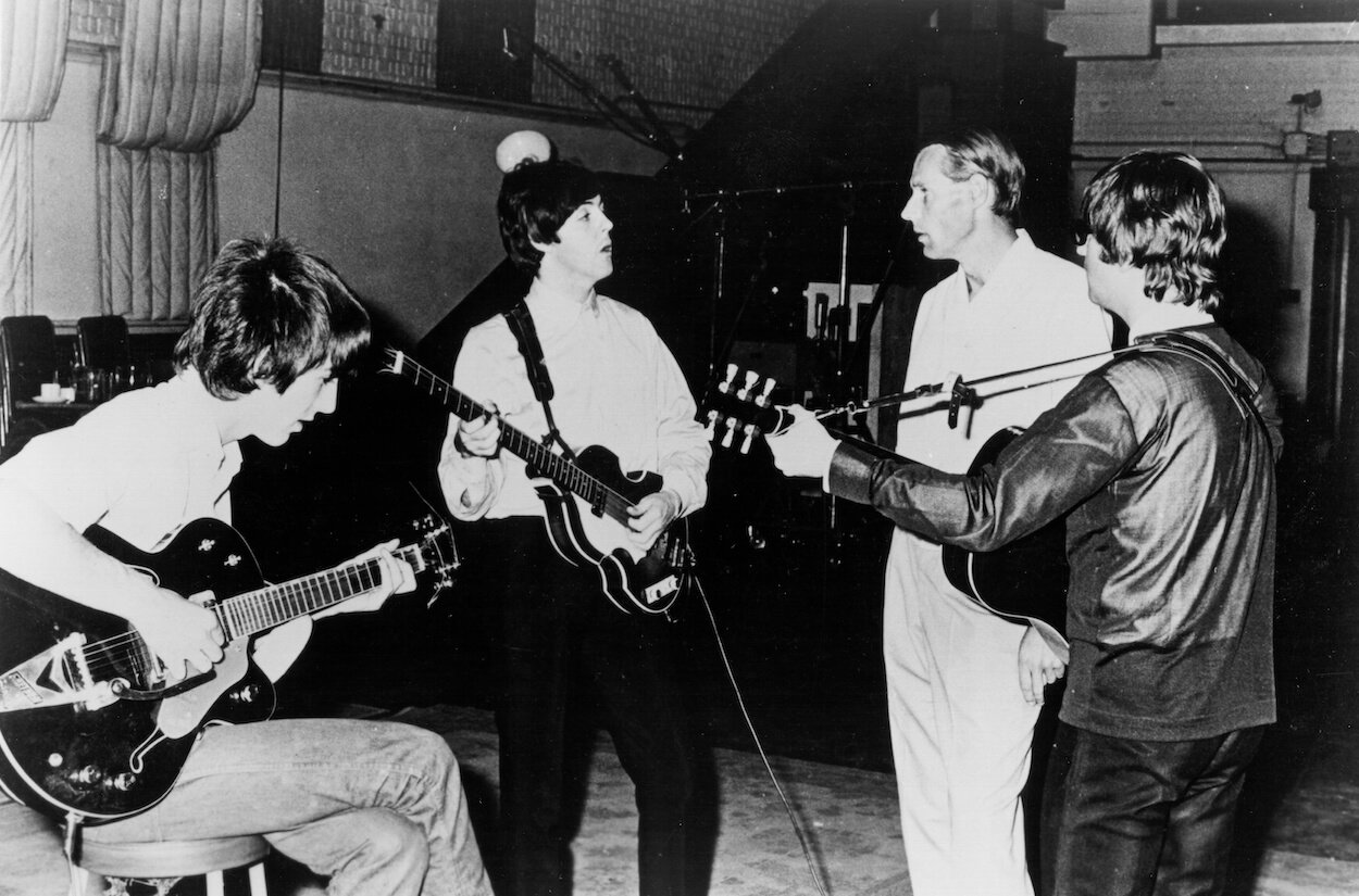 George Harrison (from left), Paul McCartney, George Martin, and John Lennon in Abbey Road Studios circa 1964.