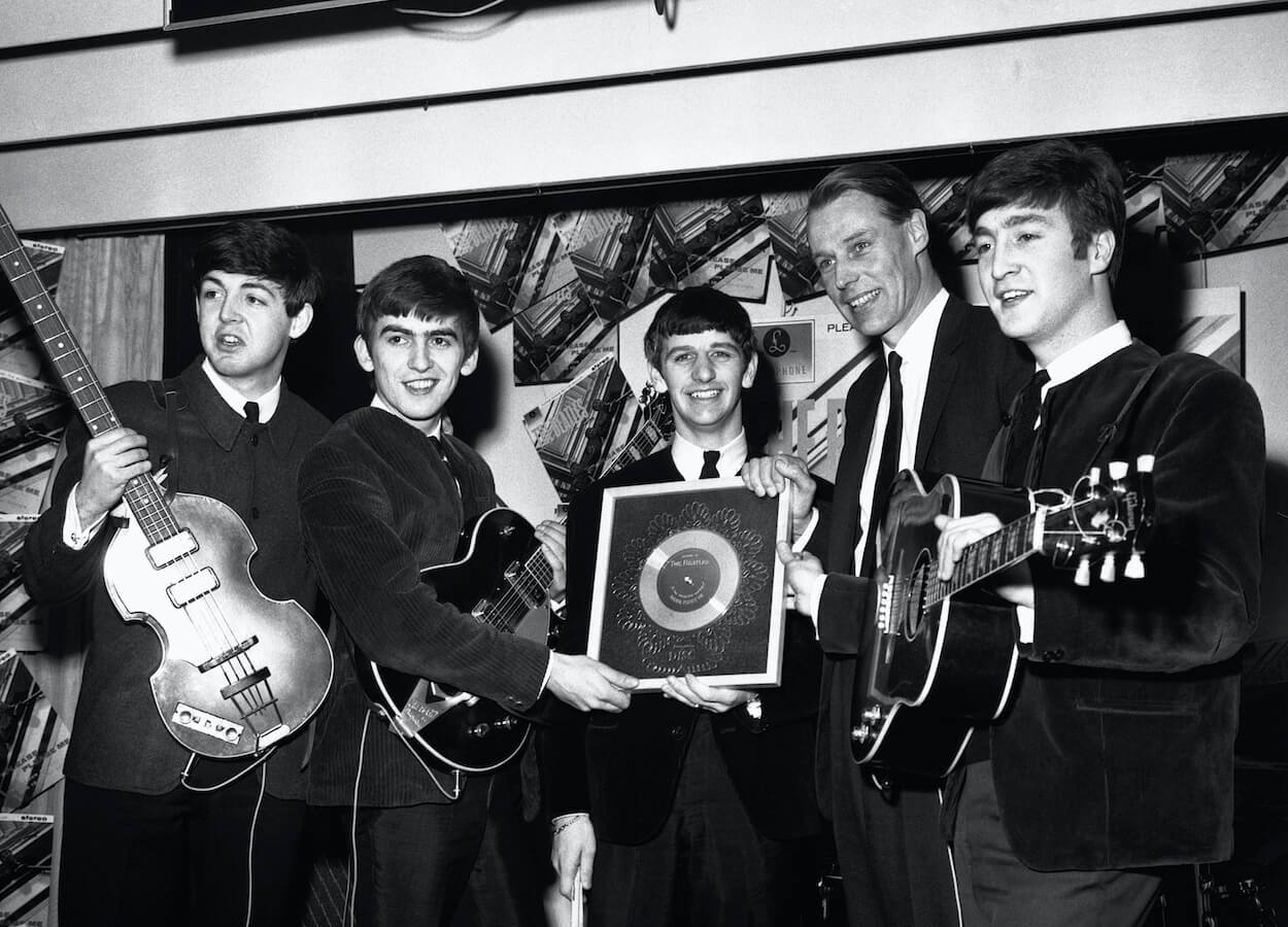 The Beatles and producer George Martin received a silver record for the success of the 'Please Please Me' single in 1963.
