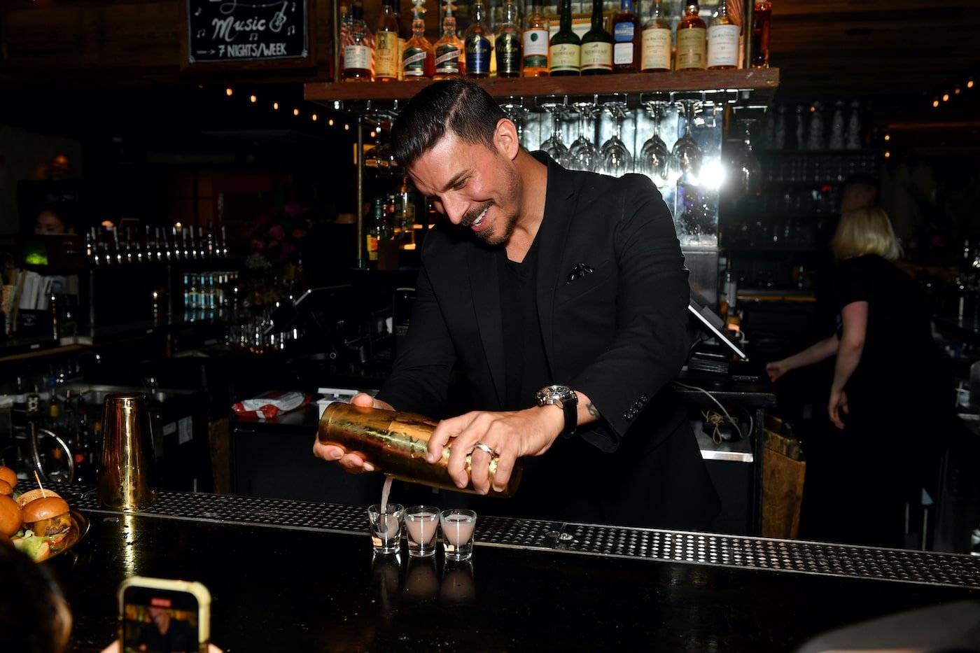 Jax Taylor pours a drink at a bar