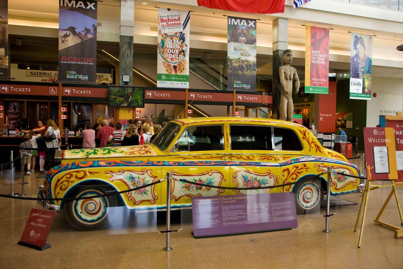 John Lennon's yellow, floral-patterned Rolls-Royce is in a museum exhibit.