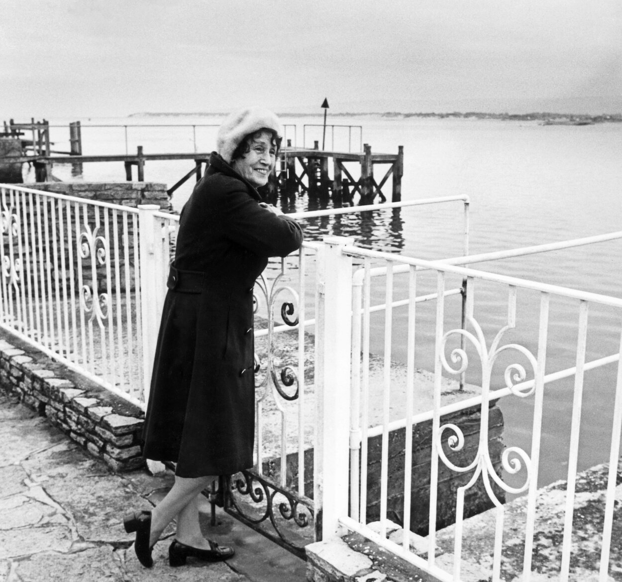 John Lennon's aunt Mimi standing near an iron fence looking out over Poole Harbour in England.