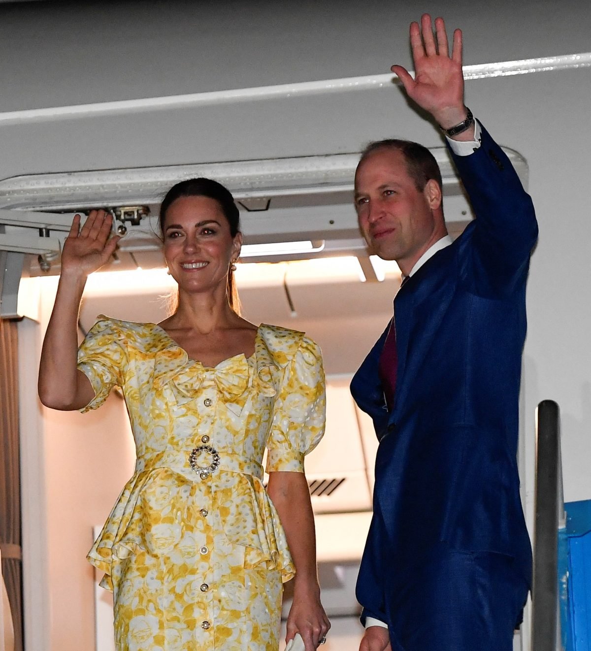 Kate Middleton and Prince William wave from their aircraft during the departure ceremony at Lynden Pindling International Airport in Nassau, Bahamas