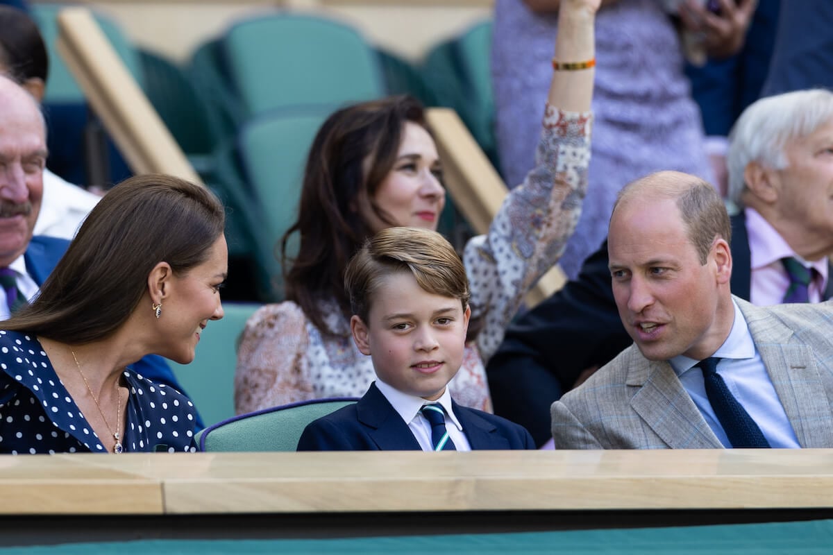 Kate Middleton and Prince William, whose public displays of affection toward Prince George started to 'decline' after Prince George began wearing suits, sit with Prince George
