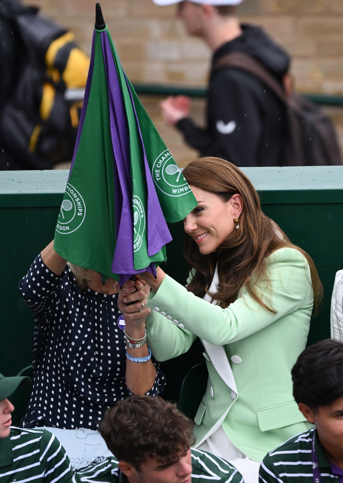 Kate Middleton opening an umbrella as rain stops play at Wimbledon on Day 2