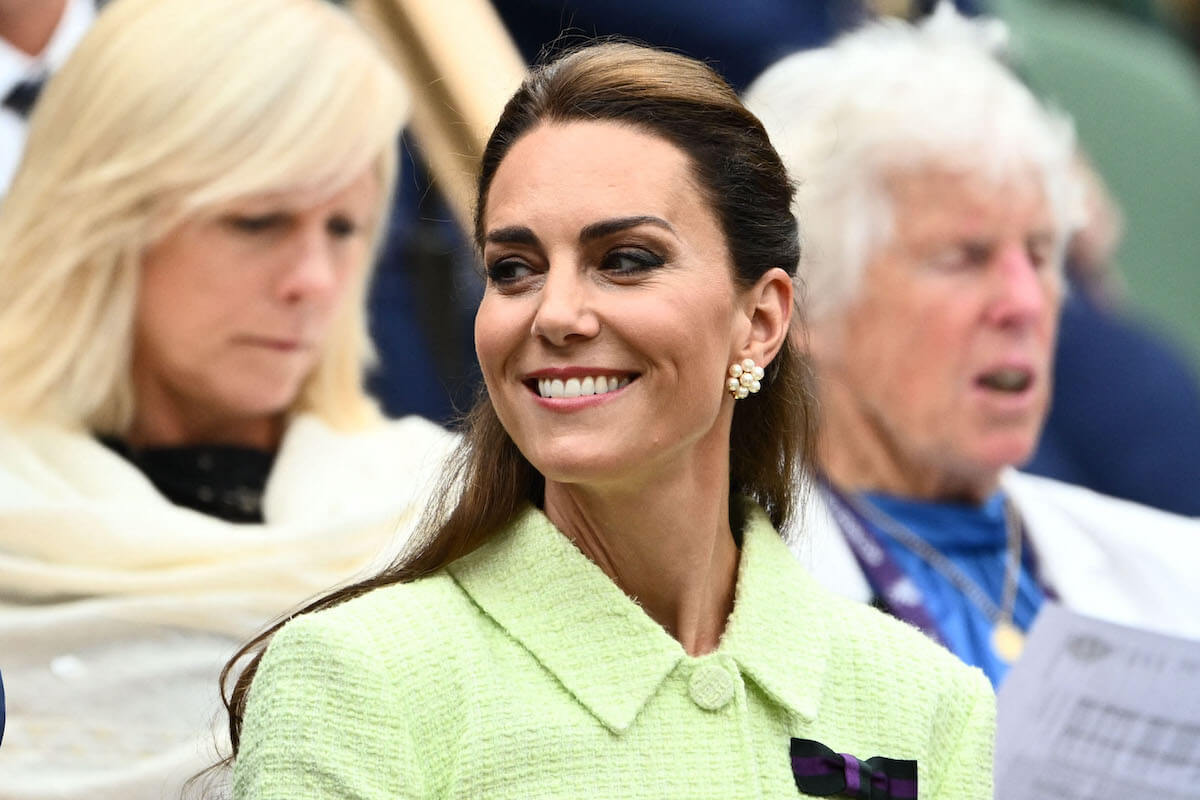 Kate Middleton, whose 'leadership style' consists of three body language traits, looks on and smiles wearing green