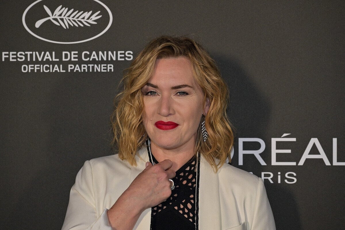 Kate Winslet taking a picture in a white and black outfit at a photocall for the L'Oreal Paris event 'Lights on Women' .