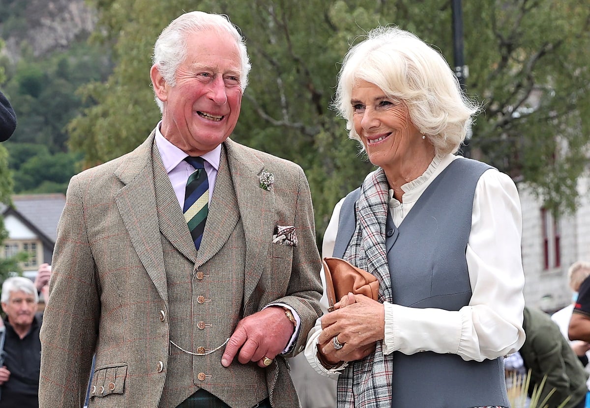 King Charles III and Camilla Parker Bowles (now-Queen Camilla) visit local shops and businesses during a walk through a village in Ballater, Scotland