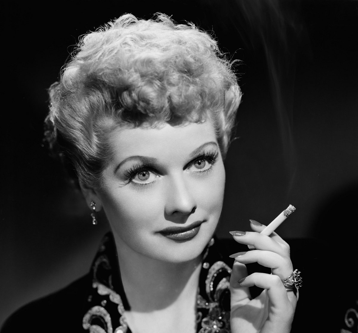Lucille Ball poses for a portrait while holding a cigarette, circa 1940