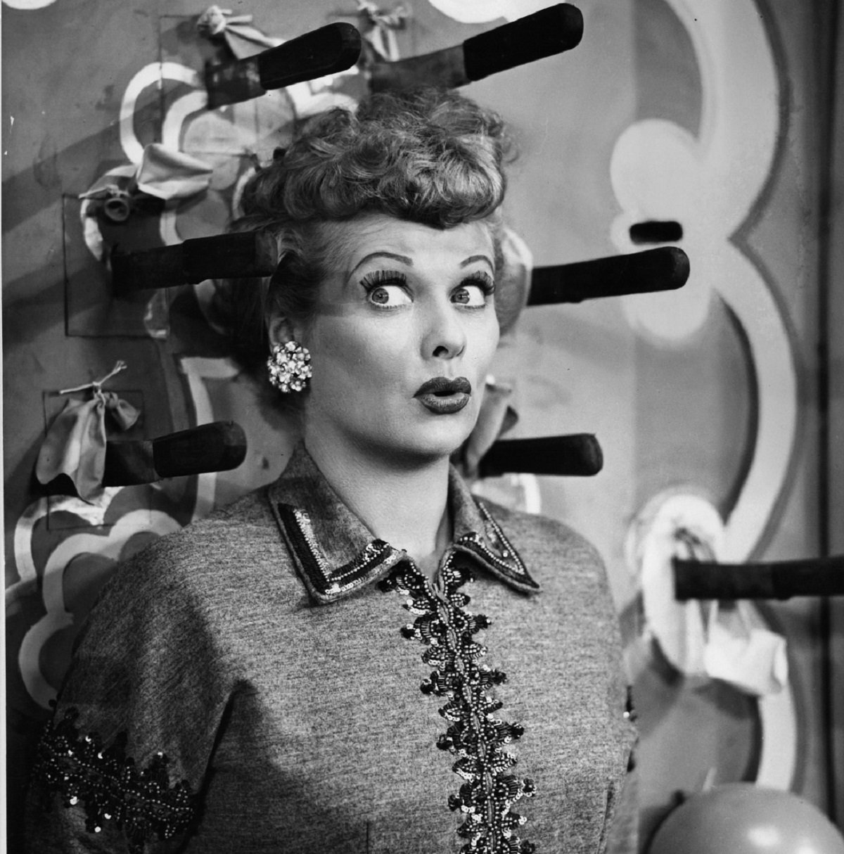 Lucille Ball as Lucy Ricardo has knives thrown at her in an episode of 'I Love Lucy'