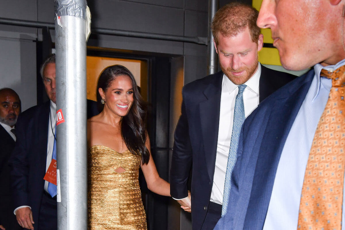Meghan Markle, who publishers are 'scared' to publish paparazzi images of, per a photographer, holds hands with Prince Harry