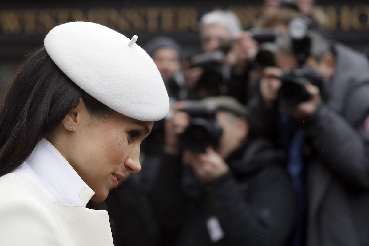 Meghan Markle, whom publishers are 'scared' to publish any tabloid photos of, per a photographer, looks on wearing white