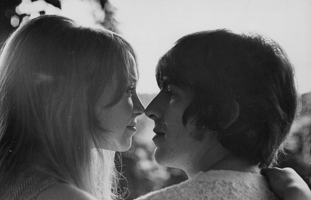 Pattie Boyd and George Harrison touching noses.