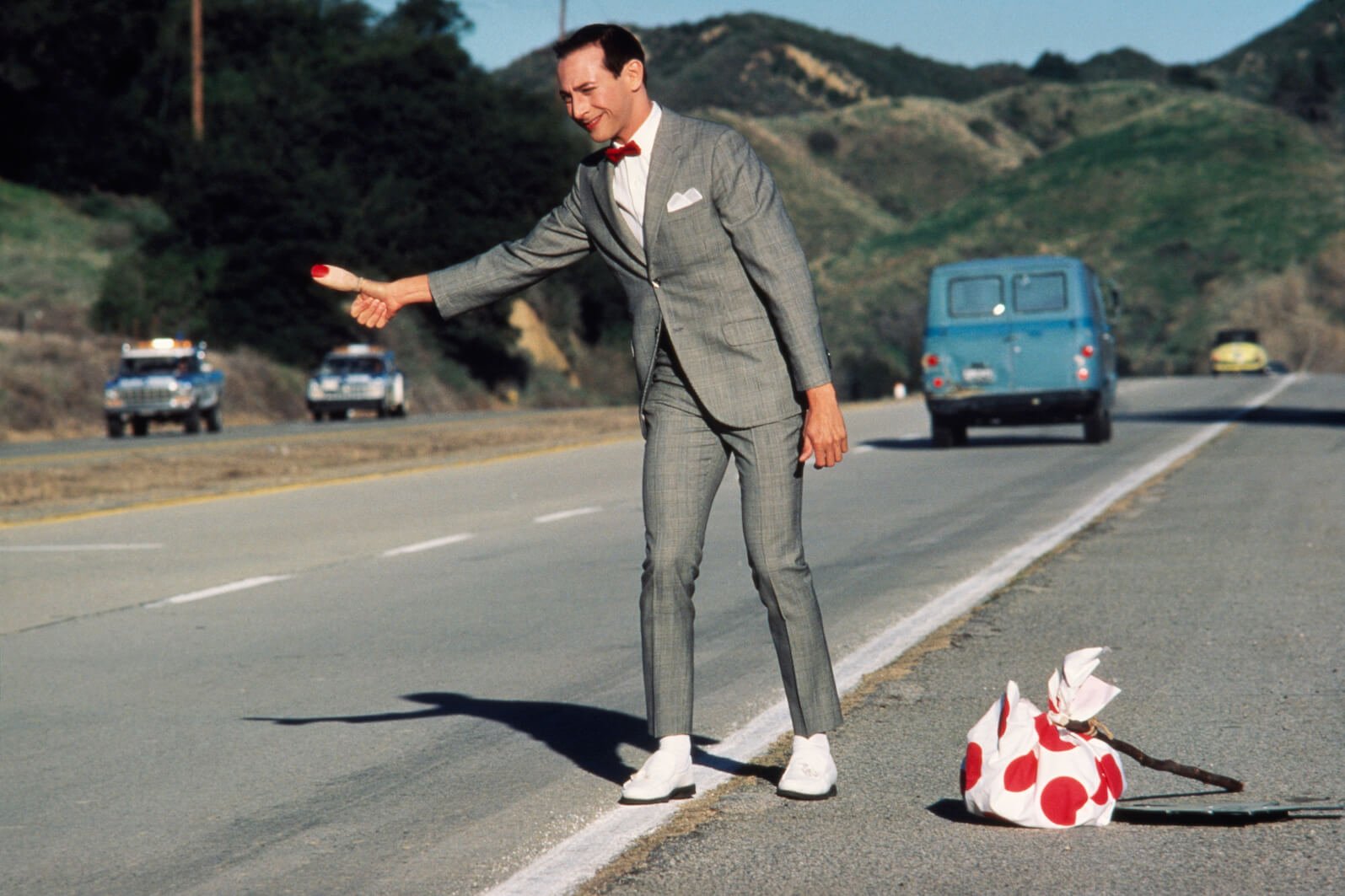 Paul Reubens as Pee-wee Herman trying to hitchhike