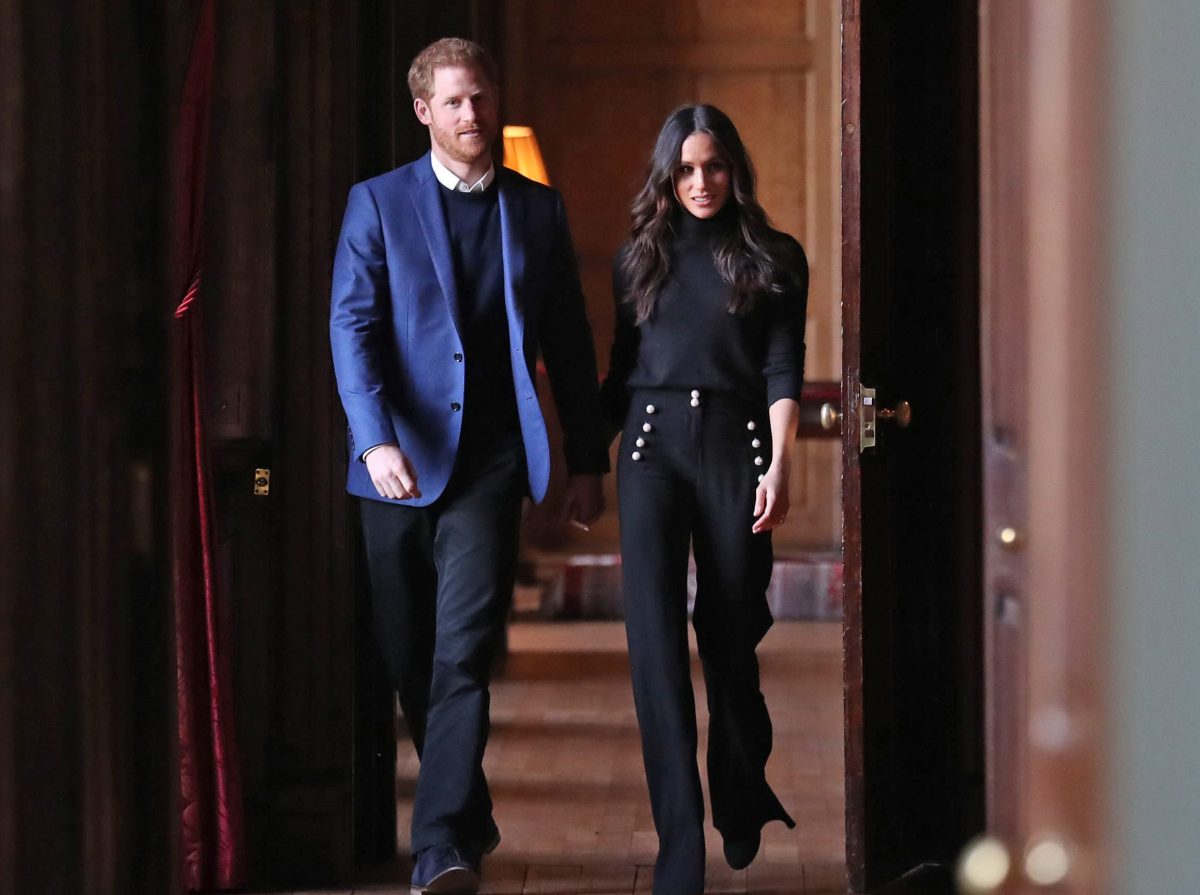 Prince Harry and Meghan Markle, who a former butler says are only famous for being royals, walk through the halls of the Palace of Holyroodhouse on their way to a reception.