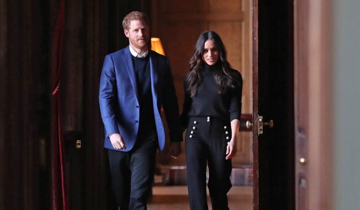 Prince Harry and Meghan Markle, who a former butler says are only famous for being royal, walking through the corridors of the Palace of Holyroodhouse on their way to a reception