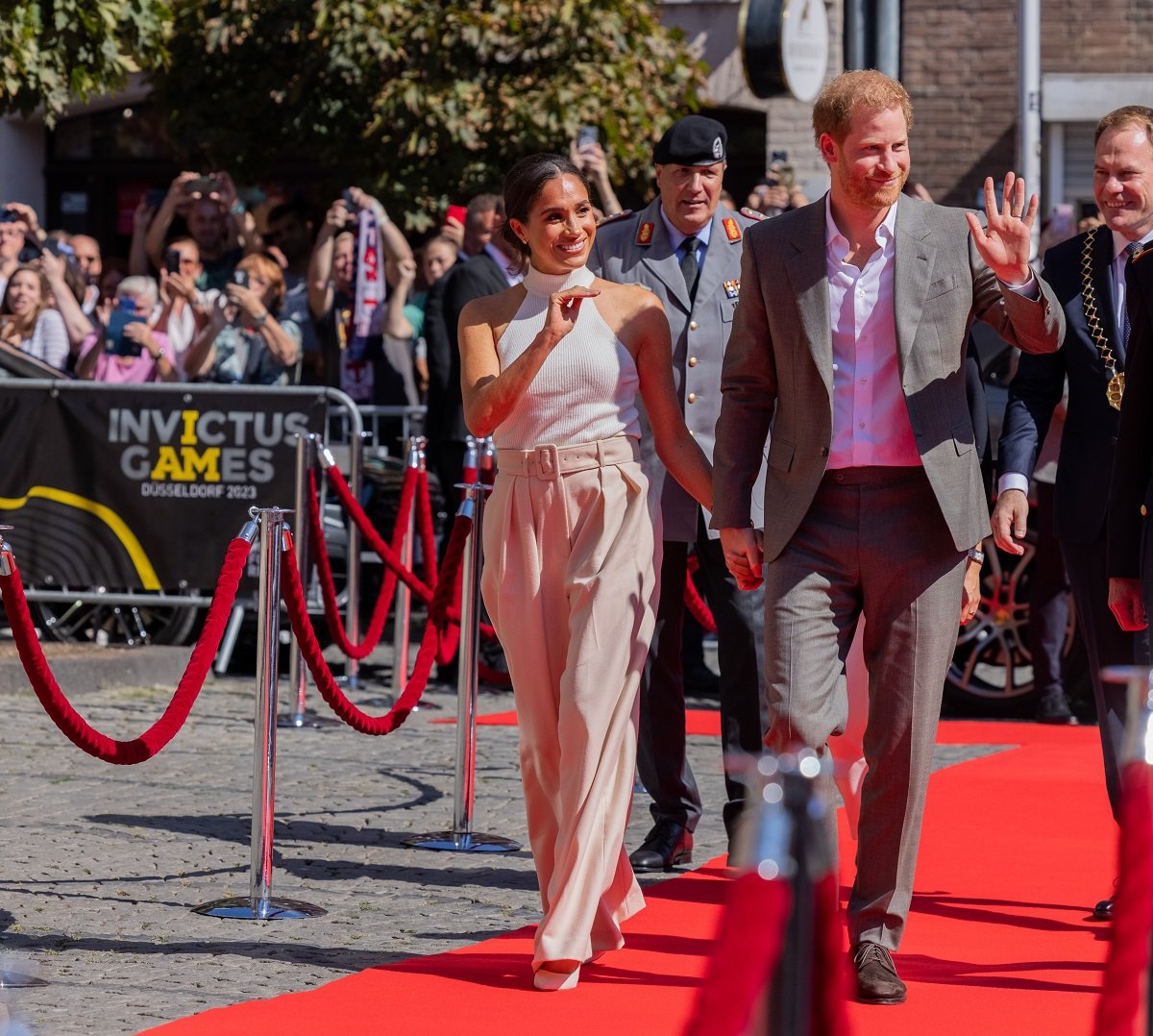 Prince Harry and Meghan Markle, whose body language on the red carpet changed after she became a royal, arrive in front of City Hall and walk a red carpet in Düsseldorf, Germany