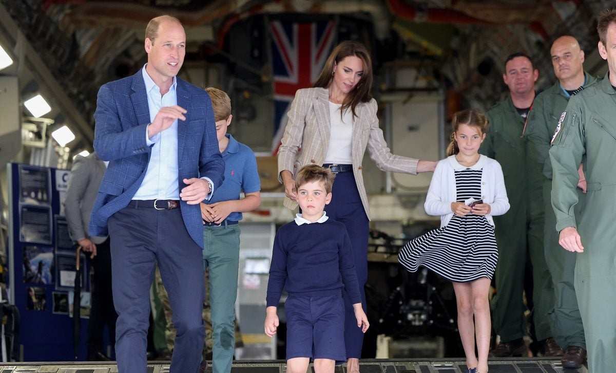 Prince William and Kate Middleton, who a former royal employee says won't force their children to stay at Balmoral in the summer, walk down the ramp of a C17 with their three kids in Fairford, England