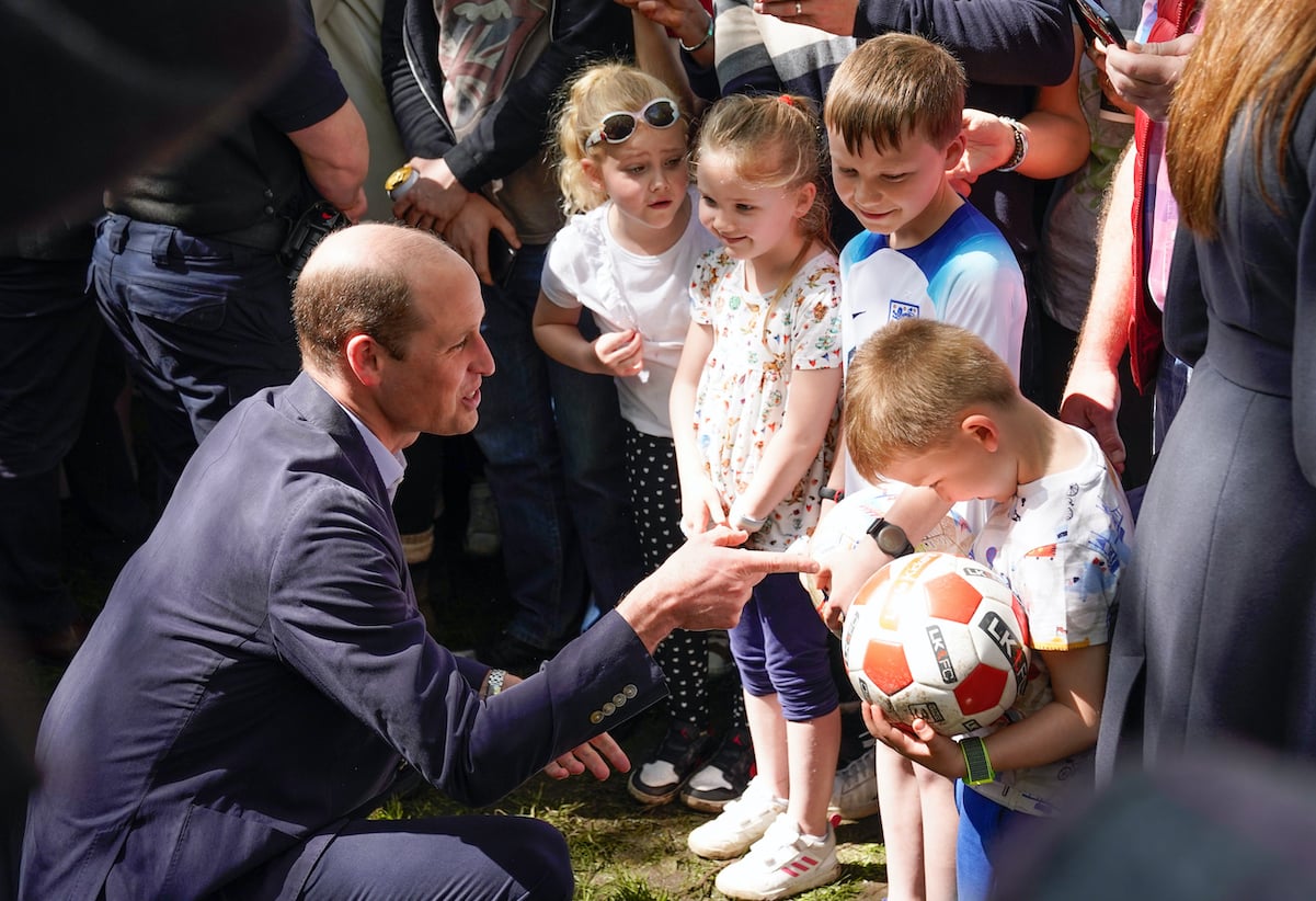 Prince William greets children during a royal walkabout to celebrate King Charles' coronation in May 2023