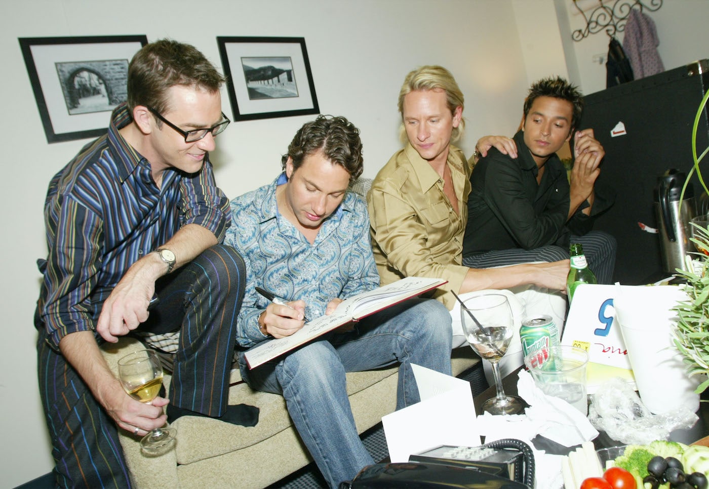 Carson Kressley signs a book while Ted Allen, Thom Filicia and Jai Rodriguez from 'Queer Eye for the Straight Guy' look on